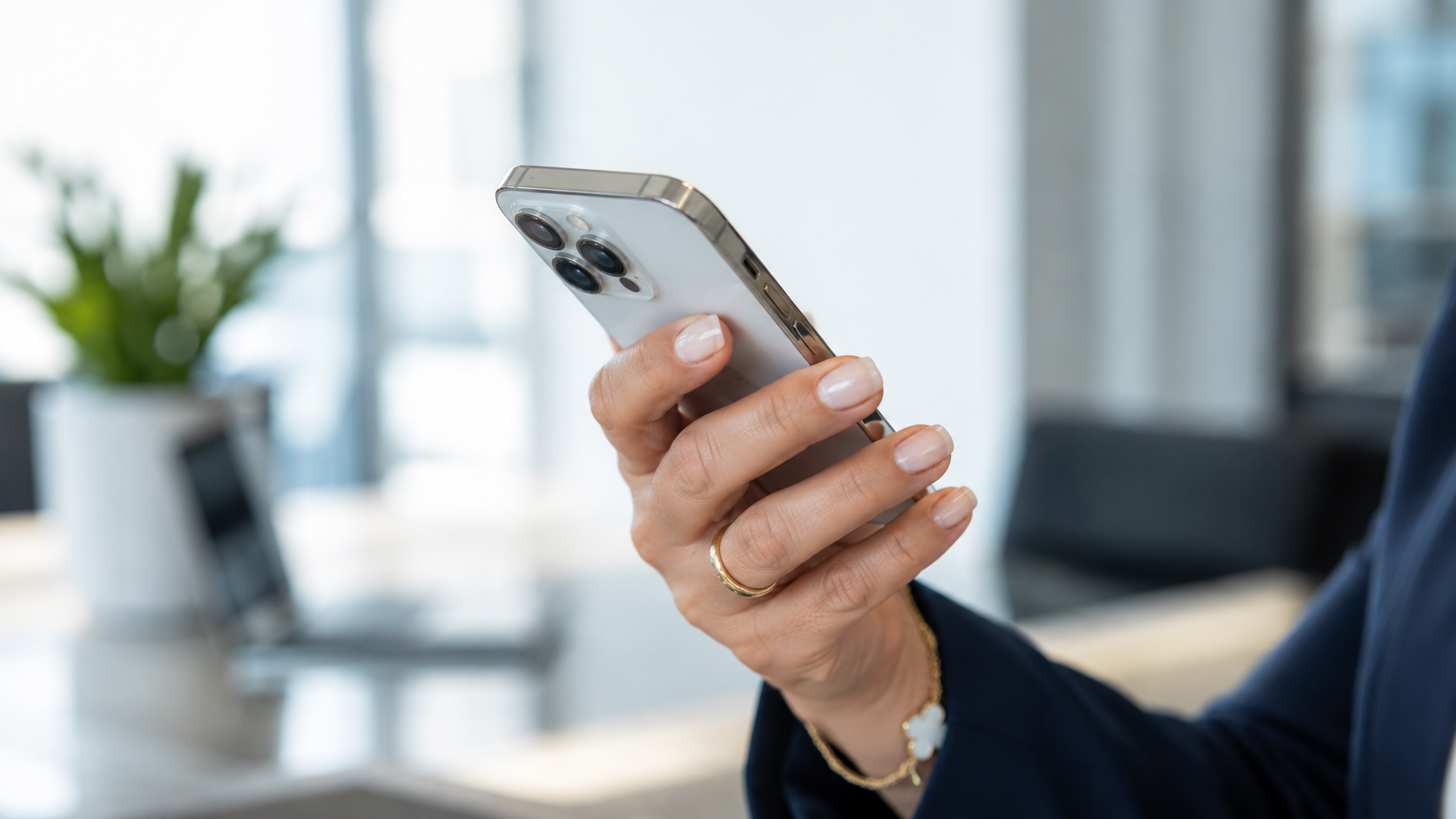 Mano che tiene uno smartphone in ufficio — contatti Corifin